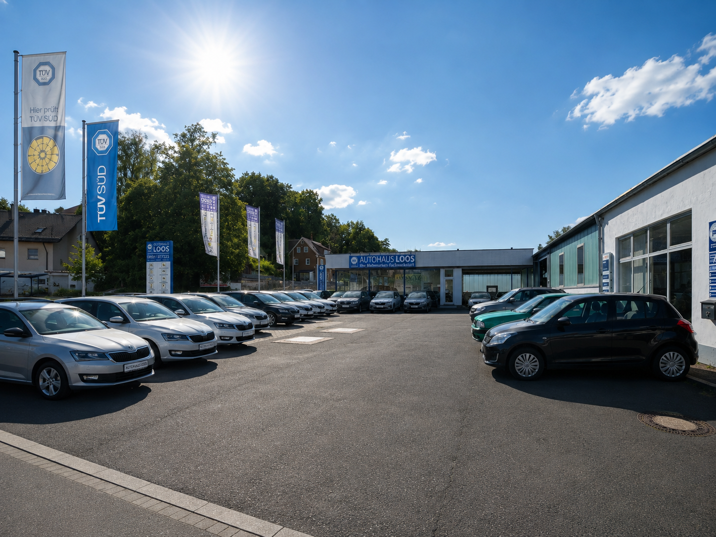 Autohaus Loos — Außenansicht mit Fahrzeugen auf dem Hof (KI-generierte Darstellung)